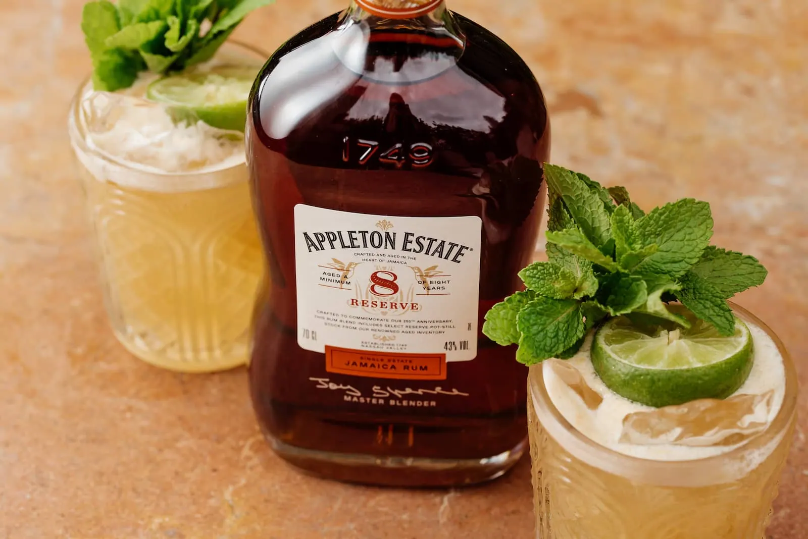 Aged Jamaican rum poured into two cocktails finished with mint and lime.