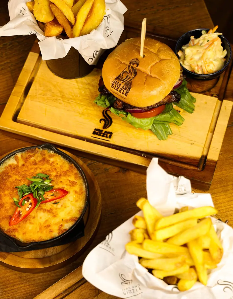 Burgers and fries served on wooden boards for a table to share.