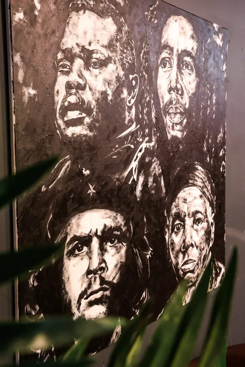 Hand-painted portrait artwork of cultural icons hanging in the lounge.